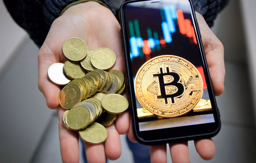 Coins beside a phone showing a trading chart